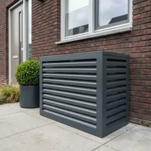 Airco ombouw van aluminium in antraciet tegen de gevel van een huis